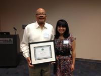 Incoming chair Sheena Gregg presents a plaque of appreciation to outgoing chair Michael Jackson.